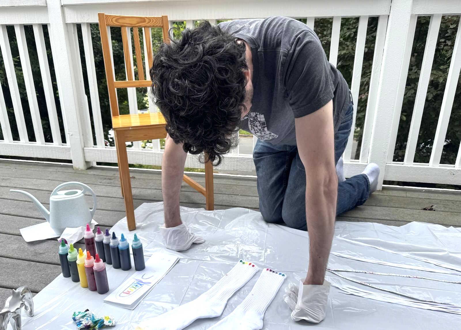 man on his knees staring at the dyed socks